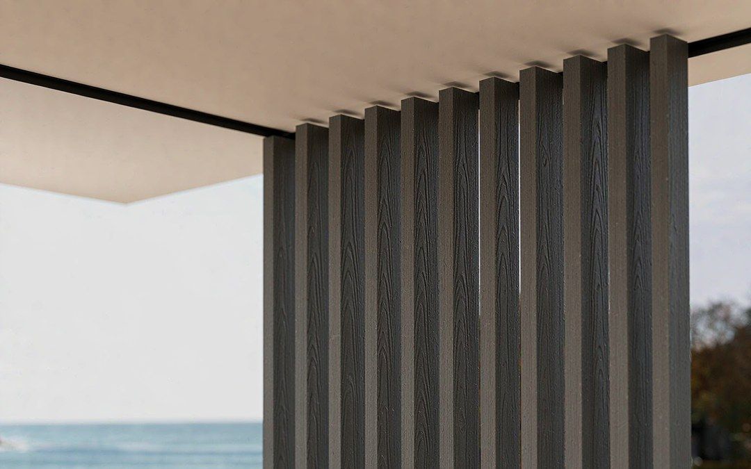 Dark grey WPC column surface with embossed wood grain texture